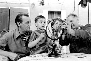 Jean Giono dispense une leçon d&#039;astronomie au petit Frédéric, sous le regard de ses parents Jacqueline et Marcel Pagnol, sur le tournage du film «Les lettres de mon moulin» à Manosque en 1954.