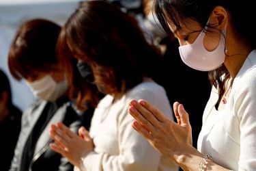 Des Japonais prient en silence à Tokyo, le 11 mars 2022.