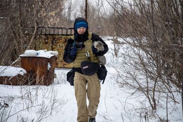 Maksim Levin portant un chat près de la ligne de front dans le Donetsk, le 25 janvier 2022.