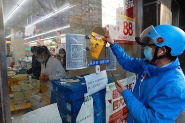 Un livreur récupère une commande de médicaments dans une pharmacie du district de Huangpu, à Shanghai, en Chine, le 17 avril 2022.