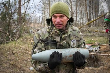 Un soldat ukrainien ramasse un explosif à Hostomel, le 18 avril 2022.
