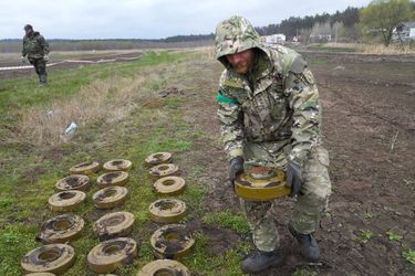 Un soldat ukrainien rassemble les mines découvertes à Irpin, le 19 avril 2022.