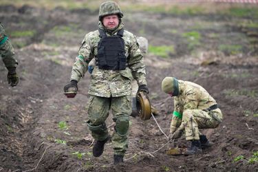 Des soldats ukrainiens rassemblent les mines découvertes à Irpin, le 19 avril 2022.
