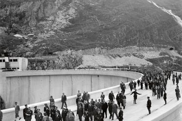 Le président Vincent Auriol et divers officiels marchent sur le haut du barrage. Entrepris en 1946, l’année de son élection, les travaux sont achevés un an avant son départ de l’élysée en décembre 1953.