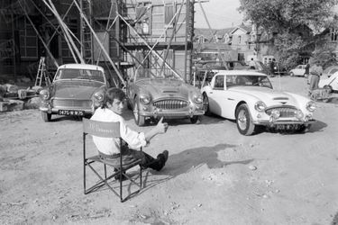 Amateur de belles mécaniques, Bébel devant trois Austin Healey présentées au Salon de l’auto 1961. Il tourne alors «Cartouche », de Philippe de Broca.
