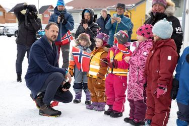 Le prince Haakon de Norvège avec des enfants devant la bibliothèque de Longyearbyen au Svalbard, le 20 avril 2022  