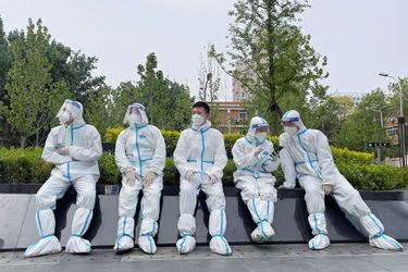 Des travailleurs en tenue de protection se reposent près d&#039;un site de test à Pékin, en Chine, le 29 avril 2022.
