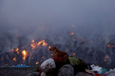 Bhalaswa, l'immense décharge de New Delhi, est en feu. Des familles gagnent leur vie en fouillant cette montagne de 60 mètres de haut, espérant trouver des objets à vendre pour des revenus dérisoires.