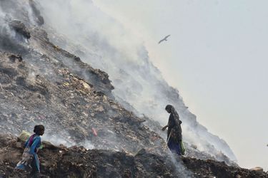 Bhalaswa, l&#039;immense décharge de New Delhi, est en feu. Des familles gagnent leur vie en fouillant cette montagne de 60 mètres de haut, espérant trouver des objets à vendre pour des revenus dérisoires.
