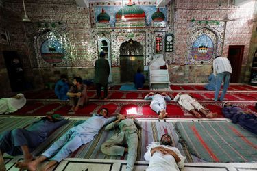 A la mosquée de Karachi, au Pakistan, des hommes se reposent sous la chaleur, le 2 mai.