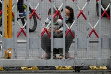 Des résidents chinois derrière une barrière durant le confinement à Shanghai.