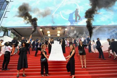 Les membres du groupe féministe Les Colleuses font irruption sur le tapis rouge du Festival de Cannes, lors de la montée des marches pour le film "Holy Spider", le 22 mai 2022. Elles ont affiché les noms des 129 femmes mortes à cause de violences domestiques.