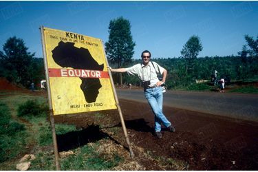 Benoit Gysembergh devant un panneau indiquant l’équateur, au bord d’une route du parc national Meru, au Kenya.