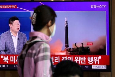 Une femme regarde une télévision diffusant un reportage sur le lancement par la Corée du Nord de trois missiles, dont un considéré comme un missile balistique intercontinental (ICBM), à Séoul, Corée du Sud, le 25 mai 2022.