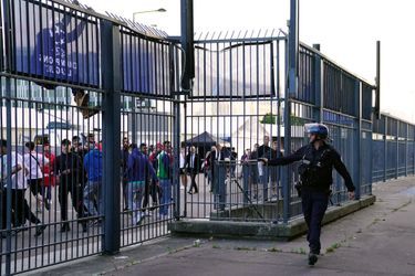 Un policier éloigne des supporters des grilles du Stade de France avec une bombes lacrymogène au poivre.