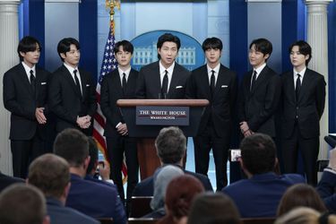 Le leader du groupe BTS, RM, prend la parole entouré des six autres membres, mardi au pupitre de la salle de presse de la Maison-Blanche.