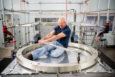 Le technicien Ryan Fischer serre l&#039;anneau d&#039;un dynamomètre sur une table utilisée pour les tests de vibration des engins spatiaux au NASA Goddard Space Flight Center. Denny Henry a remporté la première place de la catégorie &quot;Individus&quot;.