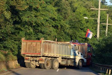 Un drapeau serbe photographié alors que des camions bloquent une route à Zupce, au Kosovo, le 1er août 2022.