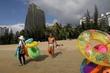 Vendeurs ambulants et touristes sur une plage de Sanya, sur l'île d'Hainan, en Chine, en 2020. 