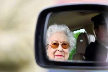 La reine Elizabeth II se reflète dans le miroir d'une voiture, alors qu'elle regarde des chevaux en compétition le deuxième jour du Royal Windsor Horse Show et de la célébration du jubilé de platine à Windsor, en Grande-Bretagne, le 13 mai 2022. 
