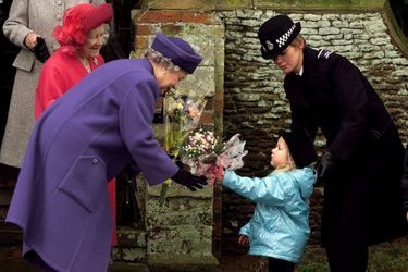 La reine Elizabeth II de Grande-Bretagne reçoit un bouquet de fleurs pendant que la reine mère s'occupe du service du matin de Noël à l'église de Sandringham, en Grande-Bretagne, le 25 décembre 1998. 