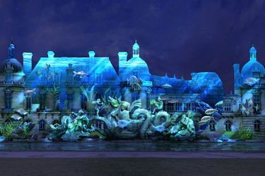 L'une des projections illustrant l'épisode de la fête grandiose pour Louis XV, sur le château de Chantilly, dans le spectacle "Chantilly, le Rocher aux Trésors" de 2022