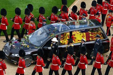 Des grenadiers escortent le cercueil alors que la procession suivant le cercueil de la reine Elizabeth II, à bord du corbillard d'État, se déplace à l'intérieur du château de Windsor le 19 septembre 2022, avant le service d'engagement de la reine Elizabeth II de Grande-Bretagne.