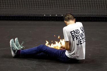 Un jeune homme vêtu d'un t-shirt avec l'inscription "Mettez fin aux jets privés au Royaume-Uni", s'est précipité sur le court avant de mettre le feu à une substance inflammable sur son bras. 