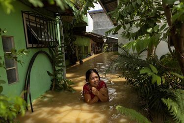 Une femme dans une rue inondée de San Ildefonso, après le passage du typhon Noru.