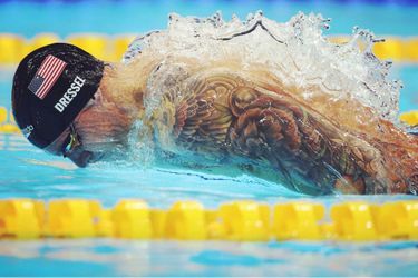 Second de la catégorie "Sport" :  Ian Macnicol. Caeleb Dressel, de l'équipe des États-Unis, en plein effort pour remporter la finale du 100 mètres papillon masculin au Tokyo Aquatics Center. L'eau s'enroule autour de son corps comme un manteau, créant un effet d'optique intéressant. <br />
