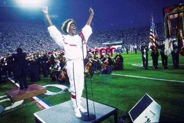 Avec un orchestre symphonique, Whitney Houston chante l'hymne national lors du Superbowl XXV au stade de Tampa en Floride le 27 janvier 1991.