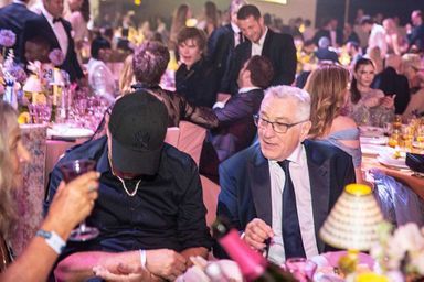 Leonardo DiCaprio, caché derrière sa casquette, et Robert De Niro au dîner de l'amfAR.