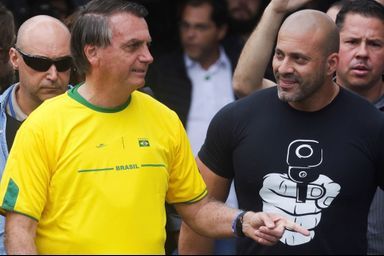 Bolsonaro a revêtu un maillot de l'équipe nationale brésilienne où il compte de nombreux supporters. A ses côtés, un proche a opté pour un tee-shirt moins pacifique.