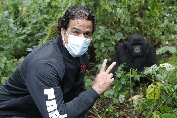 Rai poste à côté d'un gorille, lors de son passage au Rwanda.