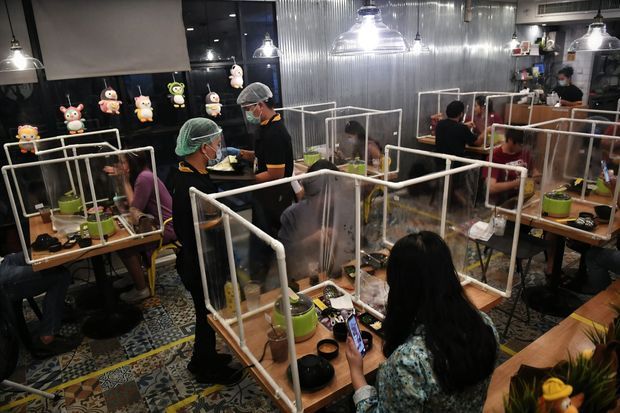Au restaurant Penguin Eat Shabu, à Bangkok, des clients isolés par des vitres en plastique