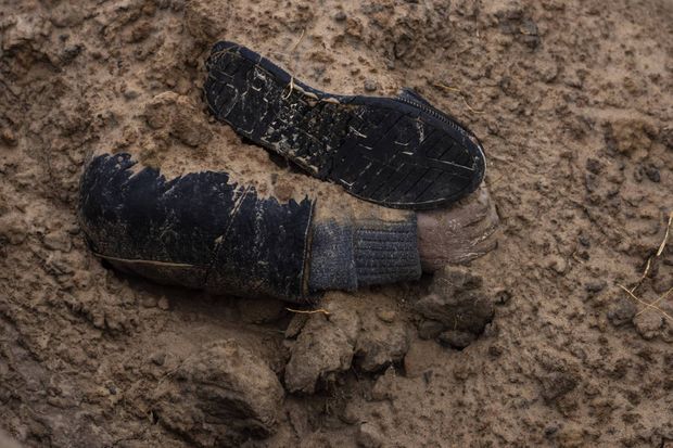 Un pied et un bras dépassent d'une fosse commune de Boutcha, le 3 avril 2022.