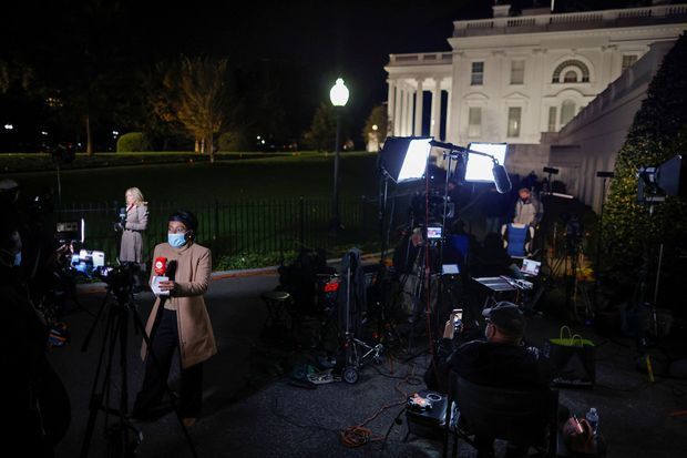 Des journalistes devant la Maison-Blanche, mardi soir.