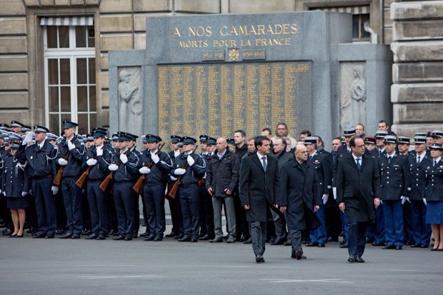Entre Manuel Valls et François Hollande, lors de la cérémonie d’hommage aux trois policiers tués, dans la cour de la préfecture de police de Paris, le 13 janvier.