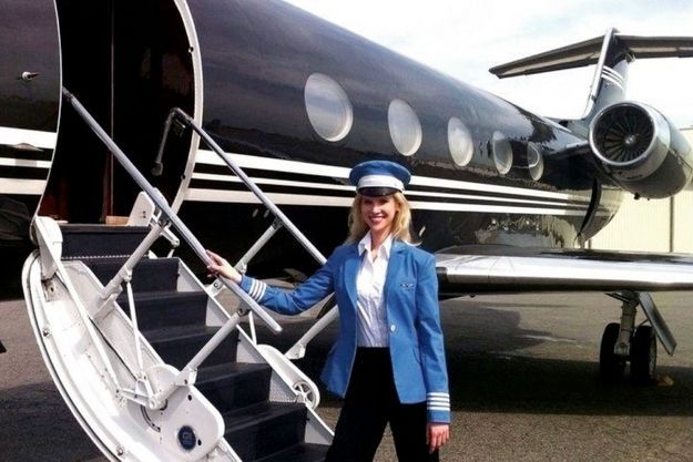 Nadia Marcinkova, en tenue de commandant de bord, devant un Gulfstream, pour la promotion de sa société Aviloop