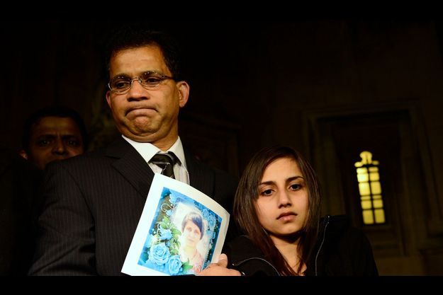  Le mari de Jacintha, Ben, avec sa fille Lisha à ses côtés, tient une photo de son épouse. 
