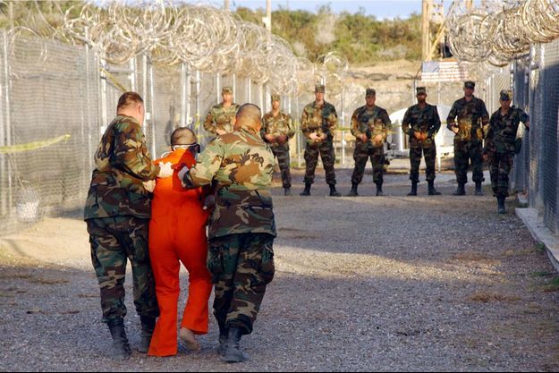 Un détenu escorté jusqu'à sa cellule dans le camp X-Ray de la base navale américaine de Guantanamo Bay, à Cuba, le 11 janvier 2002. Photo diffusée par la police militaire de l'armée américaine. 
