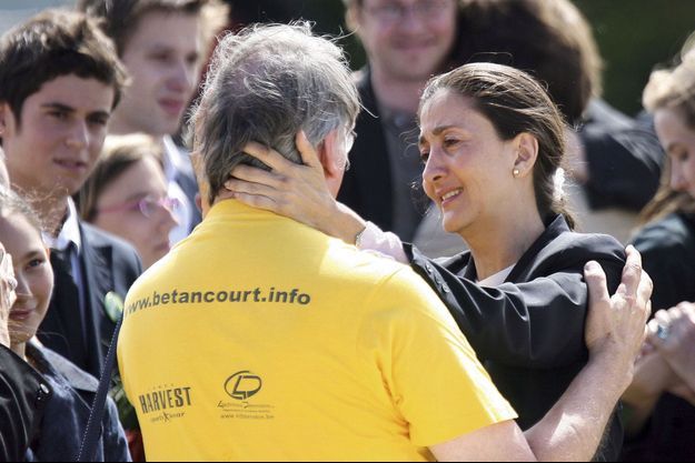 A sa descente d’avion, très émue, Ingrid Betancourt remercie l’un des bénévoles qui ont œuvré à sa libération, A gauche, Gabriel Attal.