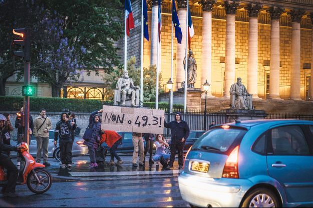 Lundi soir, des manifestants dénoncent l'éventuel recours au 49-3 devant l'Assemblée nationale, à Paris.