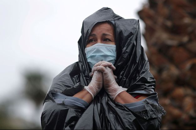 Juana Gomez, 50 ans, qui n’a pas les moyens de payer le loyer et la nourriture de ses six enfants après que son mari a perdu son emploi dans la construction, se tient sous la pluie pour récupérer des aliments frais lors de la distribution de 2000 boîtes de la Banque alimentaire régionale de Los Angeles de l'épicerie, alors que la propagation de la maladie des coronavirus continue. Juana Gomez, 50 ans, qui n’a pas les moyens de payer le loyer et la nourriture de ses six enfants après que son mari a perdu son emploi dans la construction, se tient sous la pluie pour récupérer des aliments frais lors de la distribution de 2000 boîtes de la Banque alimentaire régionale de Los Angeles de l'épicerie, alors que la propagation de la maladie des coronavirus continue.