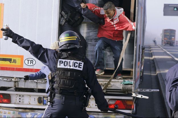 Ici à Calais en octobre 2014, des policiers évacuent des migrants cachés dans un camion.