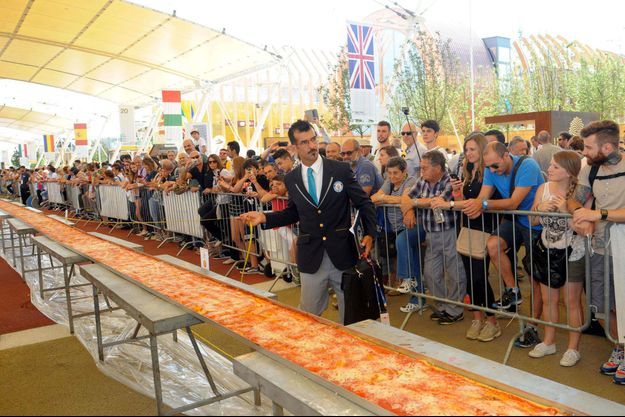 Le juge du Guinness des records en train de mesurer la pizza. 