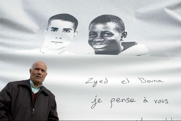 Le père de Zyed Benna pose devant un portrait de son fils et de Bouna Traoré, les deux adolescents décédés en octobre 2005. 