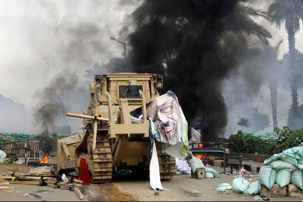 Un poster du Président déchu Mohammed Morsi a été arraché par un bulldozer lors des violents affrontements entre forces de sécurité et Frères musulmans près de l'Université du Caire et du square Nadeht Misr