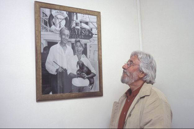 Jean-Michel Cousteau regarde un portrait de son père et de sa mère, en 2004.