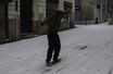 Un homme s'amuse à glisser sur la glace avec un skateboard sans roues, à Nantes.
